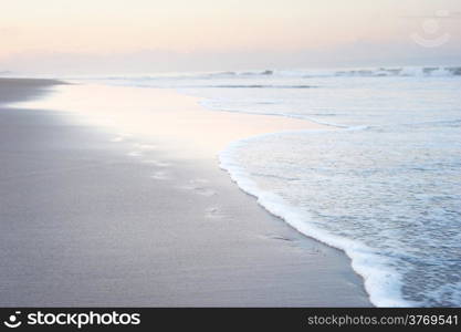 Path of a footsteps on the beach sand on Bali island at dawn