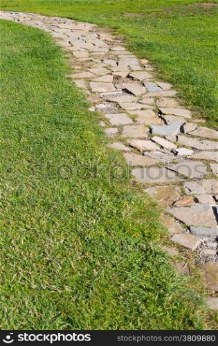 Path of stones on a green grass