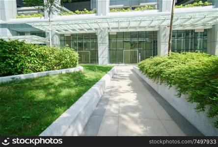 Pathway in the garden with modern office background .
