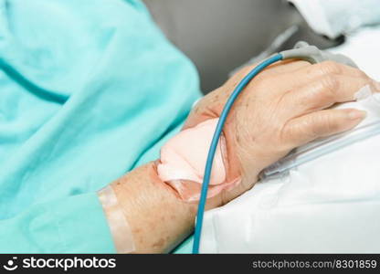 Patient asian elder woman 80s flu covid19 with pulse gauge for heartbeat measuring and blood pressure on a patient elderly finger on patient bed in intensive care unit  ICU.  room at hospital. Patient in the hospital with pulse gauge on finger