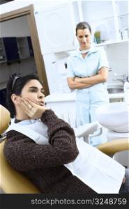 Patient describes to the dental assistant where her teeth hurt.