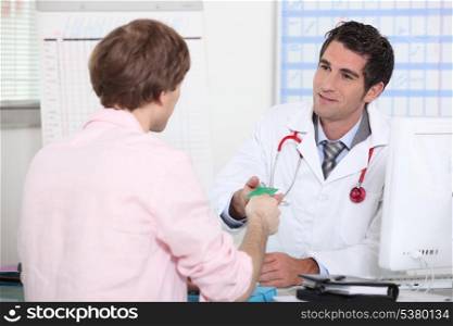 Patient handing card to doctor