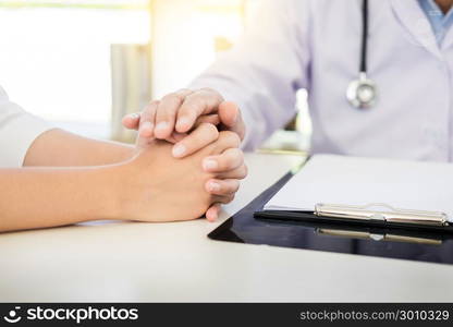 patient listening intently to a male doctor explaining patient symptoms or asking a question as they discuss paperwork together in a consultation