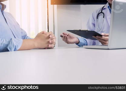 patient listening intently to a male doctor explaining patient symptoms or asking a question as they discuss work together in a consultation