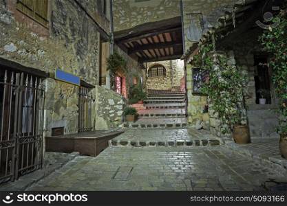 Patio cobbled with flowers in the old village Tourrettes-sur-Loup at night, France.
