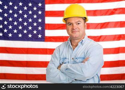 Patriotic construction worker standing in front of an American flag. Photographed in front of flag, not composite image.