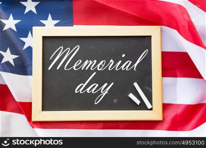 patriotism and national holidays concept - memorial day words on chalkboard, chalk and american flag. memorial day words on chalkboard and american flag