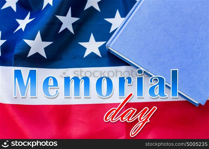 patriotism and national holidays concept - memorial day words over american flag and book. memorial day words over american flag and book