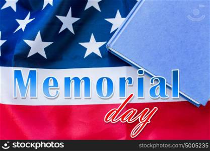 patriotism and national holidays concept - memorial day words over american flag and book. memorial day words over american flag and book