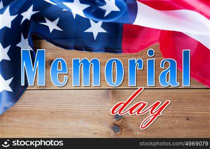 patriotism and national holidays concept - memorial day words over american flag on wood. memorial day words over american flag on wood