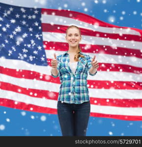 patriotism, education, gesture and people concept - smiling girl in casual clothes showing thumbs up over american flag and blue sky with snow background