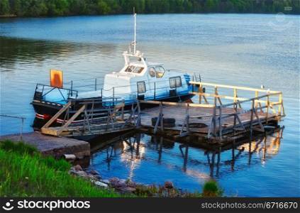 patrol boat docked on calm lake at evening