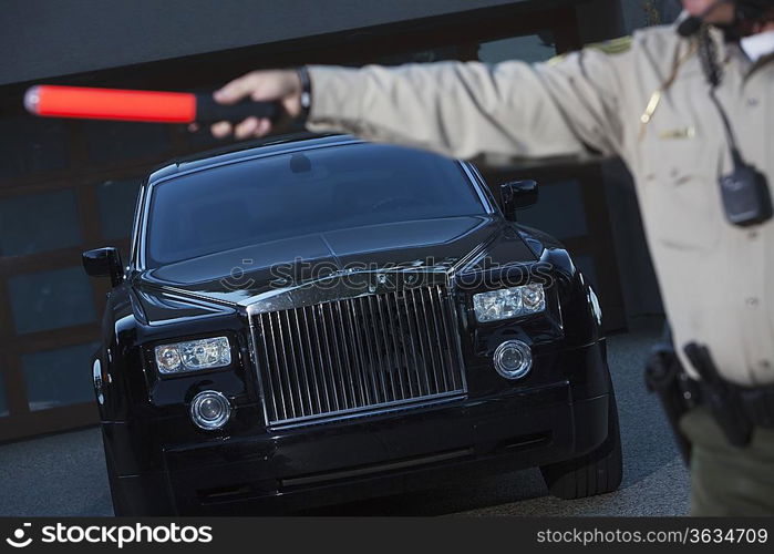 Patrol officer signals to traffic with hand baton