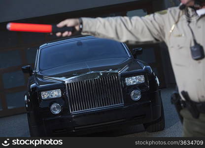 Patrol officer signals to traffic with hand baton