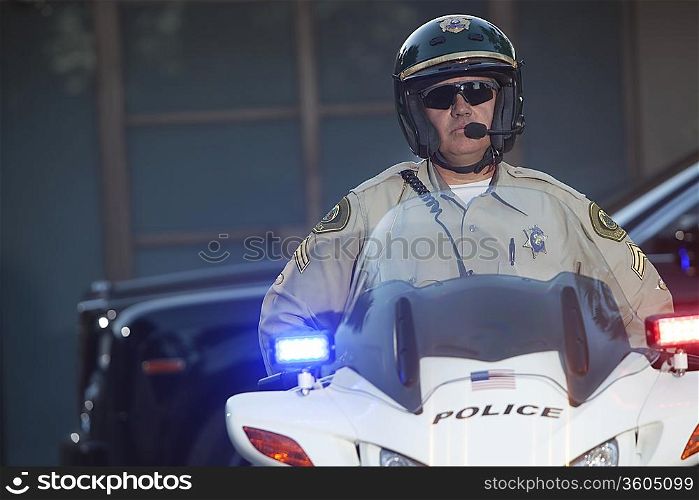 Patrol officer sits on motorcycle with hazrd lights lit
