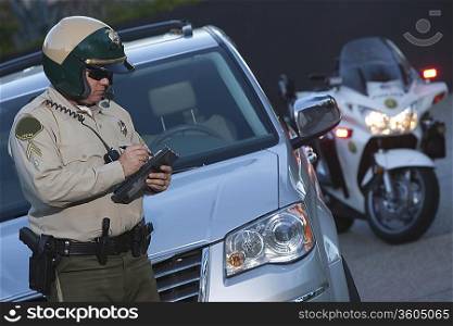 Patrol officer stands witing ticket