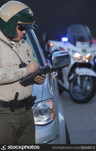 Patrol officer stands witing ticket