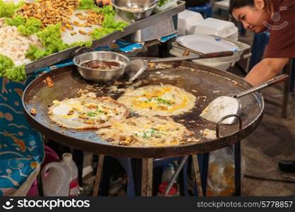 PATTAYA, THAILAND - APRIL 4, 2015: Woman in a street cafe fry food
