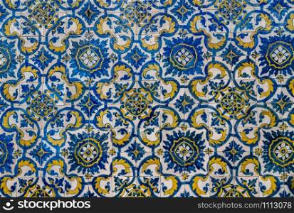 Pattern of blue and yellow old azulejo tiling on wall in traditional Portuguese style. Old azulejo tiling on wall in traditional Portuguese style