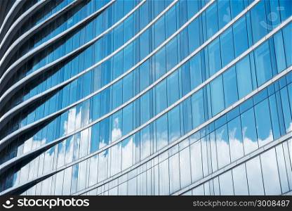 Pattern of blue glasses in high building with shadow of cloud. Abstract modern building background.