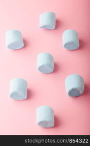 Pattern of blue marshmallows on plain pink background
