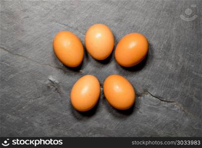 Pattern of eggs on rustic slate table for Easter. Easter background with brown organic eggs arranged on rustic slate table. Pattern of eggs on rustic slate table for Easter