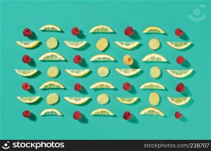 Pattern of fruit pieces of lemon and raspberry on a blue background. Food background. Flat lay. Ripe raspberry and lemon slices pattern of fruit on a blue background. Food layout. Flat lay