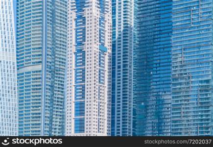 Pattern of office buildings windows. Glass architecture facade design with reflection in urban city, Downtown Dubai. Urban city in financial district with blue sky.