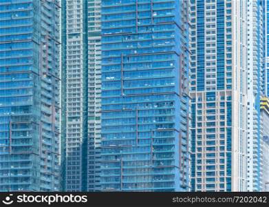Pattern of office buildings windows. Glass architecture facade design with reflection in urban city, Downtown Dubai. Urban city in financial district with blue sky.