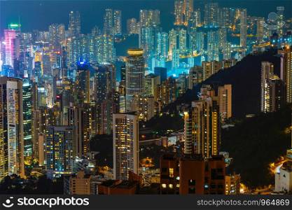 Pattern of office buildings windows illuminated at night. Lighting with Glass architecture facade design with reflection in urban city, Downtown Hong Kong City in financial district.