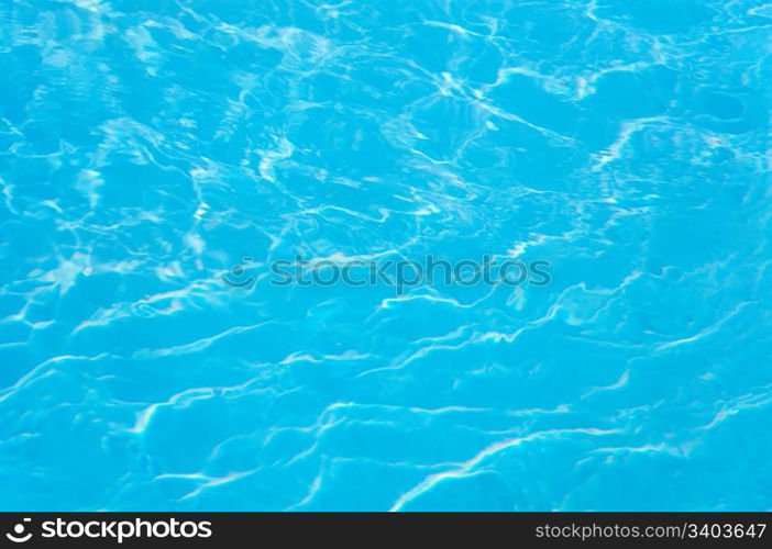 patterns of sunlight rippling o n a swimming pool water surface