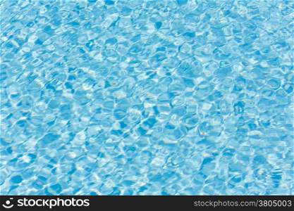 Patterns of sunlight rippling on a swimming pool water surface