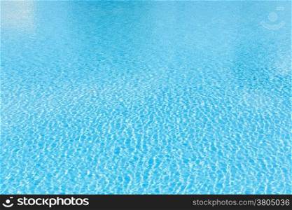 Patterns of sunlight rippling on a swimming pool water surface