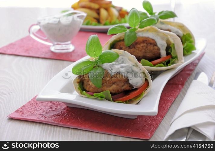 Patty in pita bread with vegetables in cream sauce
