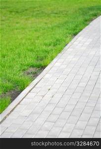 paved lane of the garden and green grass