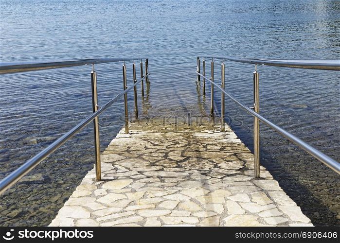 paved sea ramp with metal handrail