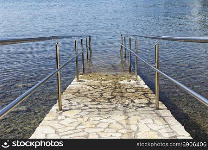 paved sea ramp with metal handrail