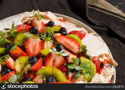 Pavlova cake with fresh blueberries, strawberries and kiwi.