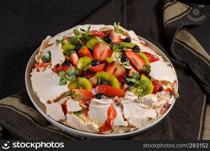 Pavlova cake with fresh blueberries, strawberries and kiwi.