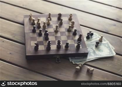 pawn of chess game and money banknote on wooden table for use in business competition concept, vintage tone and selected focus