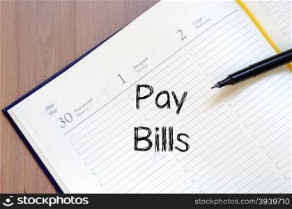 Pay bills text concept write on notebook with pen