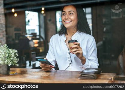 Pay for goods by credit card through a smartphone in a coffee shop.