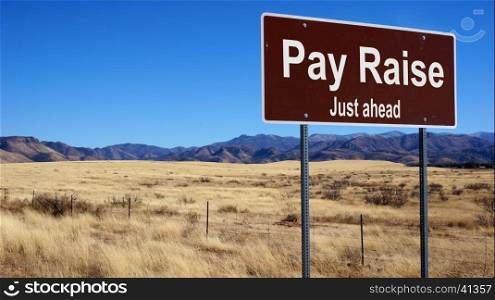 Pay Raise road sign with blue sky and wilderness