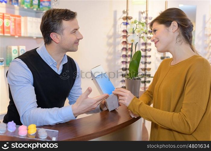 paying eye or sunglasses at optician store