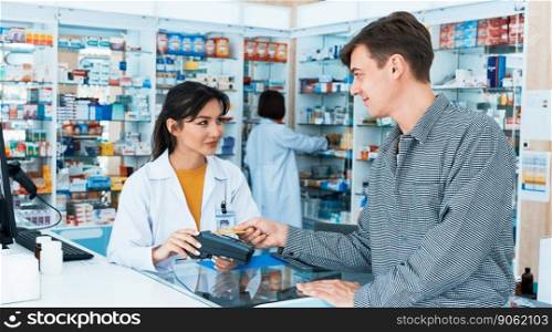 Payment by credit card with payment terminal in qualified drugstore. Modern financial payment of electric money. Caucasian customer purchase medication in pharmacy with prescription from pharmacist.. Caucasian customer purchases qualified prescription medication from pharmacist.