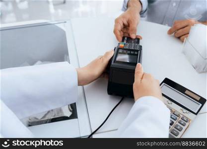 Payment by credit card with payment terminal in qualified drugstore or hospital. Modern payment of electric money. Closeup customer purchase medication in pharmacy with credit card on pos.. Closeup customer purchases qualified prescription medical drugs from pharmacist.