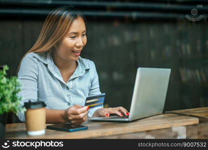 Payment for goods by credit card via notebook in coffee shop.