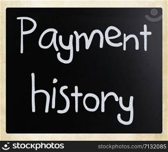 ""Payment history" handwritten with white chalk on a blackboard"
