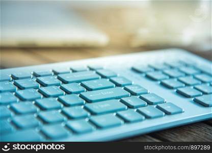 PC keyboard and cup of coffee on old weathering wooden table