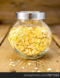 Pea flakes in a glass jar on a wooden boards background